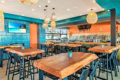 a restaurant with wooden tables and bar stools at Apartment at The Blyde in Pretoria