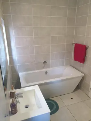 a bathroom with a white tub and a sink at Nompu b&b in Pretoria