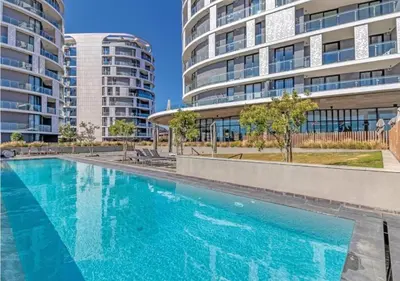 a swimming pool in front of two tall buildings at The Orbit in Midrand