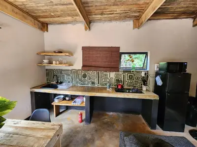 a kitchen with a table and a refrigerator at Hartbeest Bush Stay #30 in Hartbeespoort