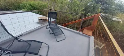 a balcony with two chairs and a bench on it at Hartbeest Bush Stay #25 in Hartbeespoort