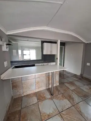 an empty kitchen with a large white counter top at Kinross house in Evander