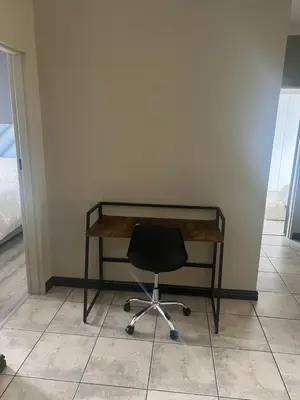 a desk with a black chair in a room at Spacious Midrand 3 Bedroom Near Gallagher, MOA & Gautrain in Midrand