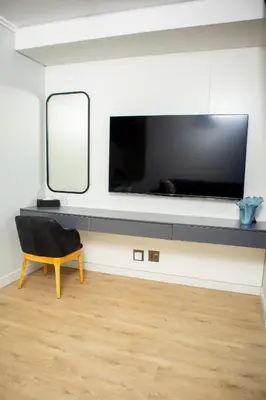 a living room with a large television on a wall at Ellipse Waterfall Premium Apartments - Blue in Johannesburg