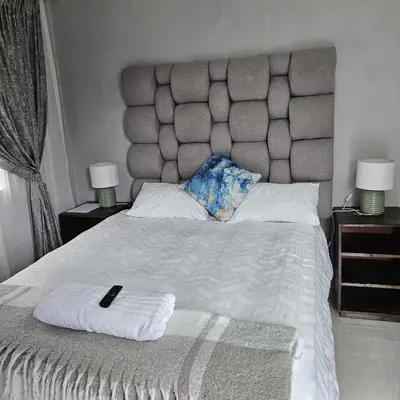 a bedroom with a large white bed with two lamps at 14 Isabel Room 2 in Centurion