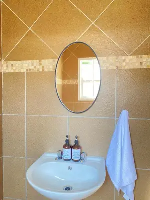 a bathroom sink with a mirror and a towel at Andisa Cozy Stay in Kempton Park