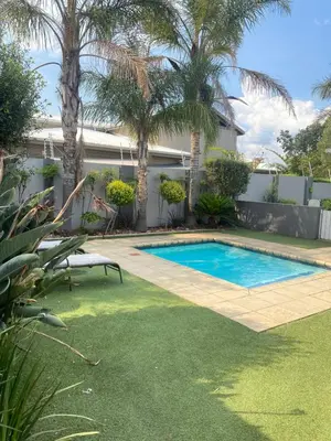 a swimming pool in a yard with palm trees at Andisa Cozy Stay in Kempton Park