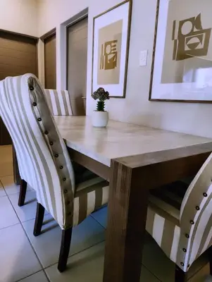a dining room table with two chairs and a wooden table at Ibunami in Midrand