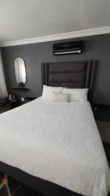 a bedroom with a large bed with a white comforter at Palma Spaces in Pretoria