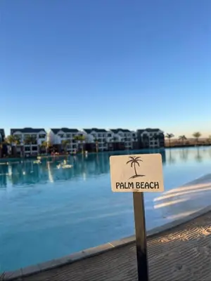 a sign in front of a swimming pool with a palm beach at The Dream Escape At The Blyde - 2 Bedroom Apartment in Pretoria