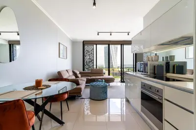 a kitchen with a table and a living room at AlimamaSpaces Moskit's Newton Place in Midrand