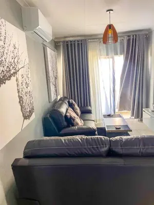 a couch in a living room with a window at chillasclub&Bnb in Nelspruit