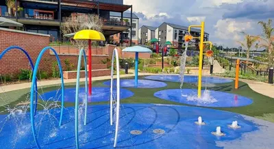 a water park with several water fountains at Home away from home in the heart of waterfall in Midrand