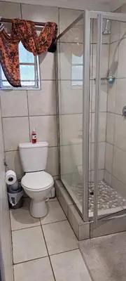a bathroom with a toilet and a glass shower at Tarentilos in Tzaneen