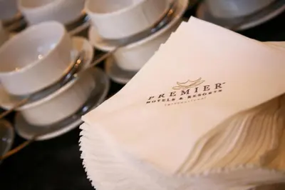 a napkin sitting on top of a pile of cups and saucers at Premier Hotel The Winkler in White River