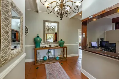 a hallway with a mirror and a counter with a mirror at Loerie's Call Guesthouse in Nelspruit