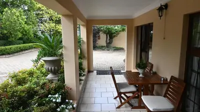 a porch with a table and chairs and a courtyard at Lamor Guest House in Middelburg