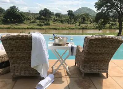 two wicker chairs and a table with a pot on it at Goedehoop Boutique Manor House in Malelane