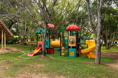 a park with a playground with slides and trees at Kruger Park Lodge Unit No. 239 in Hazyview