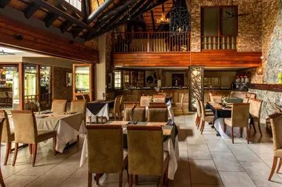 a restaurant with tables and chairs in a room at Kruger Park Lodge Unit No. 239 in Hazyview