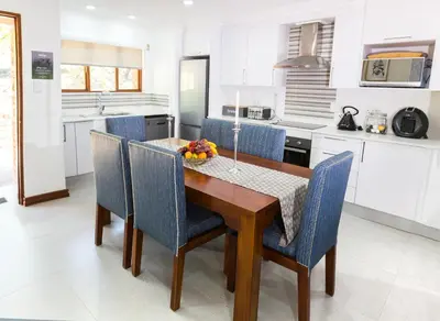 a kitchen with a wooden table and blue chairs at Kruger Park Lodge Unit No. 610A in Hazyview