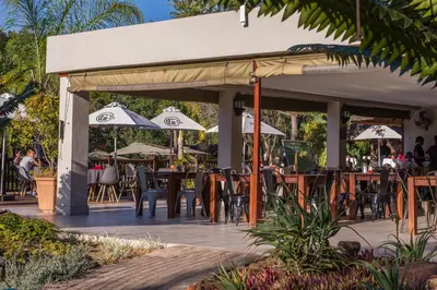 a patio with tables and chairs and umbrellas at Kruger Park Lodge Unit No. 610A in Hazyview