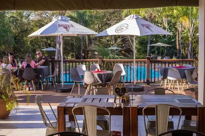 a patio with tables and chairs and umbrellas at Kruger Park Lodge Unit No. 610B in Hazyview