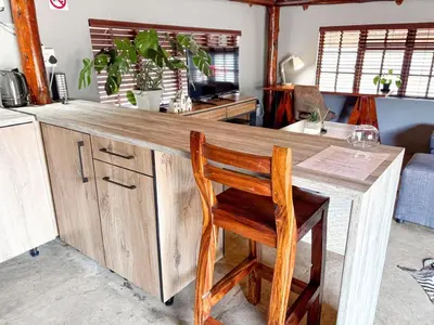 a wooden counter with a wooden chair at a table at @30 Zebra in Polokwane