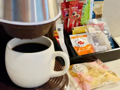 a cup of coffee sitting on a table next to a mixer at Menlyn Maine Residences - Napoli with king sized bed in Pretoria