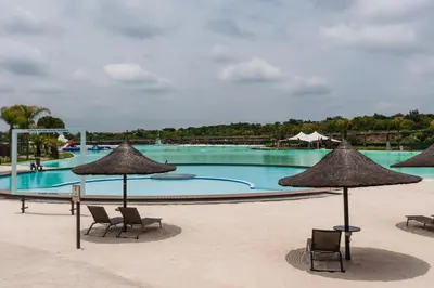 a large swimming pool with chairs and umbrellas at Alimama Spaces: The Manson's Blyde in Pretoria