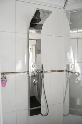 a white bathroom with a shower and a mirror at Casa de Ross in Pretoria