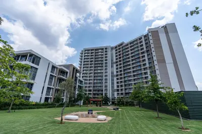 a large building with a park in front of it at Top Floor Menlyn Maine studio apartment with Stunning Views & No Load Shedding in Pretoria