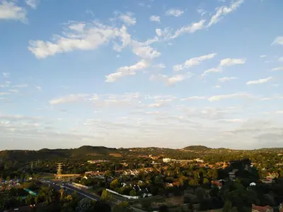 a view of a city with a blue sky and clouds at Menlyn Apartment in Pretoria