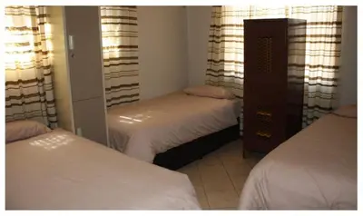 a bedroom with two beds and a mirror at Cosy farmhouse for 4 persons in Lephalale