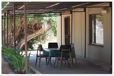 a patio with a table and chairs and a tree at Cosy farmhouse for 4 persons in Lephalale