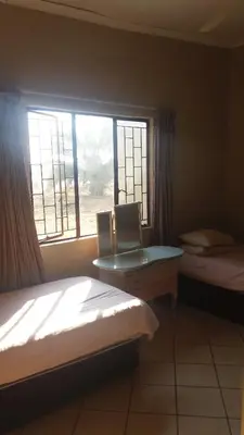 a bedroom with two beds and a window at 3 Single bedroom in farmhouse in Limpopo Province in Lephalale