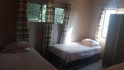 a bedroom with two beds and two windows at 3 Single bedroom in farmhouse in Limpopo Province in Lephalale