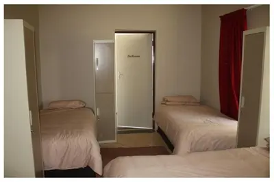 a room with three beds and a door to a closet at Old farmhouse for 3 in Limpopo Province in Lephalale
