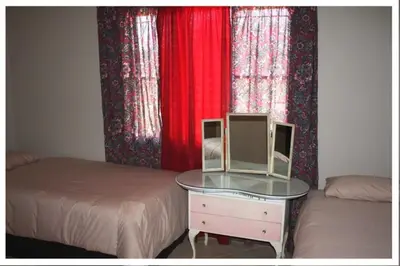 a bedroom with two beds and a table with a mirror at Old farmhouse for 3 in Limpopo Province in Lephalale
