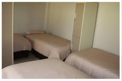 a room with two beds and a closet with mirrors at Old farmhouse for 3 in Limpopo Province in Lephalale