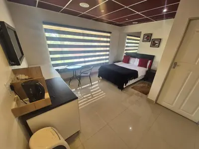 a bedroom with a bed and a table in a room at Ithonsi Guesthouse in Kempton Park