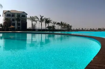 a large swimming pool with blue water and palm trees at Insaka 3 The Blyde Lagoon Experience in Pretoria
