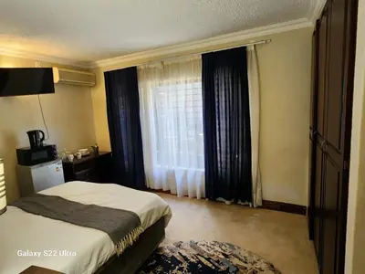 a hotel room with a bed and a window at Romantic Getaway Hartbeespoort in Hartbeespoort