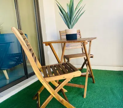a wooden chair and table with a potted plant at Phoenix Rising Apartment in Midrand