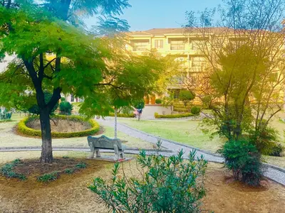 a park with a bench in front of a building at Phoenix Rising Apartment in Midrand