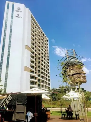 a tall white building with a large building at Menlyn Apartment - Red Velvet in Pretoria