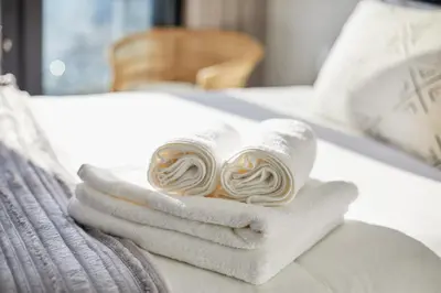 a pile of towels sitting on top of a bed at eKhaya at Ellipse Waterfall City in Midrand