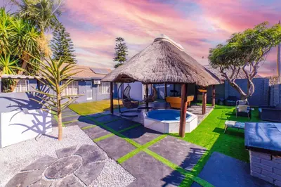 a backyard with a gazebo with a grass roof at Homes of Ace 3 bedroom Villa in Pretoria