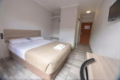 a bedroom with a bed and a television in it at Ecomotel Kempton Park in Kempton Park