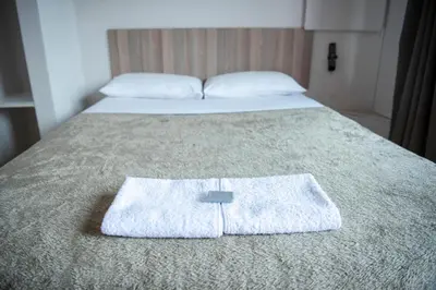 a pair of beds with towels on the bed at Ecomotel O.R.Tambo in Kempton Park
